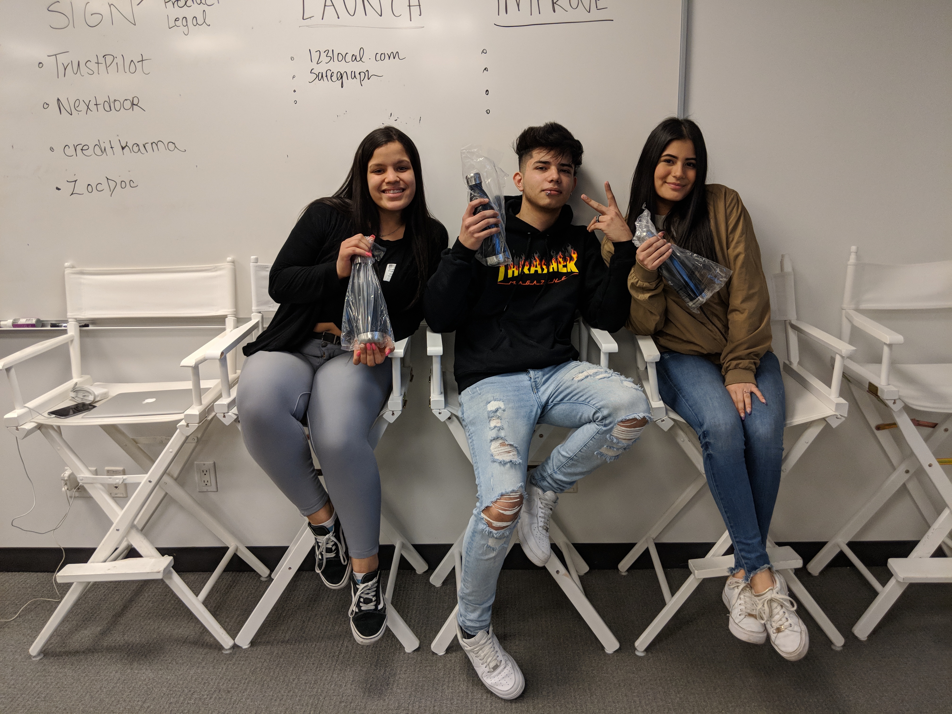 3 students posing with bottles